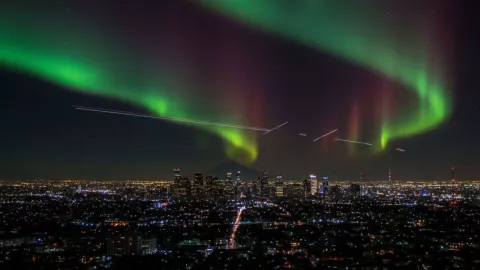 (Imagen realizada con IA) La imagen de una ciudad iluminada bajo las auroras boreales.