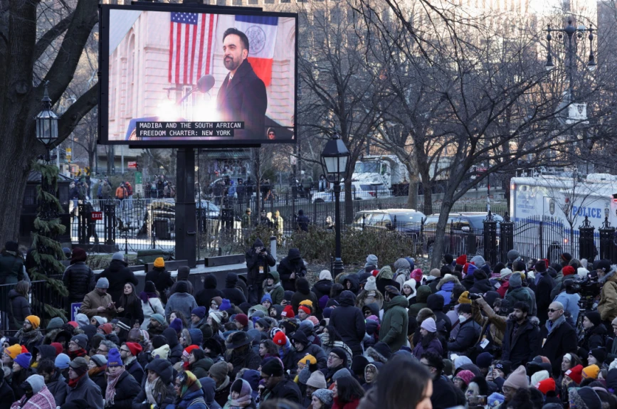 La gente observa mientras el alcalde de la ciudad de Nueva York, Zohran Mamdani, aparece en una pantalla hablando durante su ceremonia de investidura en la ciudad de Nueva York