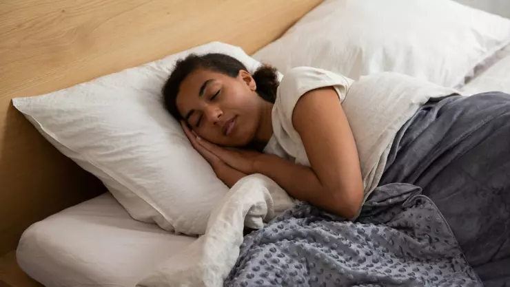 Mujer durmiendo en una cama.
