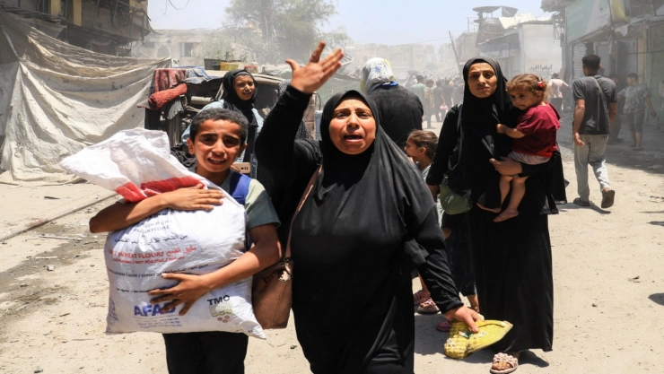 Los palestinos evacuan tras un ataque israelí en una casa en la ciudad de Gaza