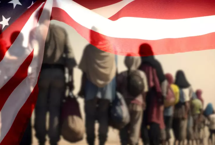 Un grupo de inmigrantes bajo una bandera de Estados Unidos.