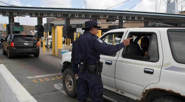 Un oficial de la CBP dirige a los coches en un puerto de entrada.