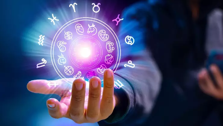 un hombre sostiene un holograma de los signos zodiacales