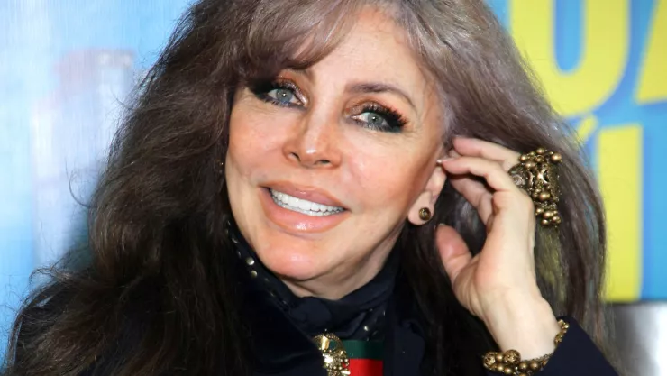 Foto de la actriz Verónica Castro con canas, maquillaje y arreglándose el cabello