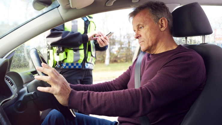 Hombre recibe multa de un oficial en su auto