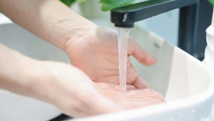 Persona lavándose las manos en lavabo