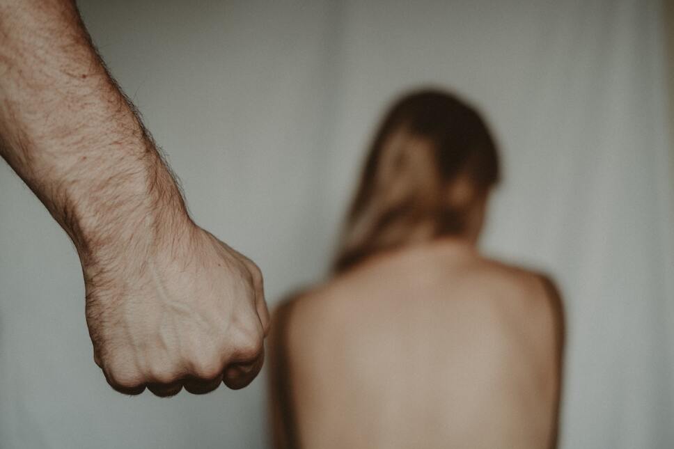 puño de hombre frente a mujer de espaldas violencia