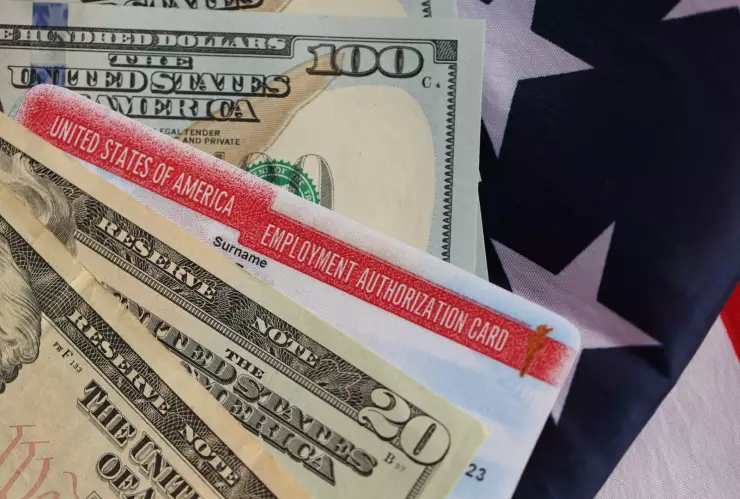 Una autorización de empleo en Estados Unidos junto a dólares