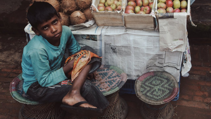 Un niño vendiendo fruta.