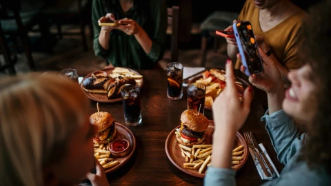 Cuatro personas comen hamburguesas en un restaurante
