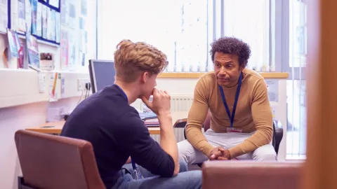 Dos estudiantes están reunidos en una sala de una universidad.