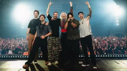 Músicos de la banda Linkin Park posando para tomarse foto con el publico de fondo después de un concierto desde el escenario