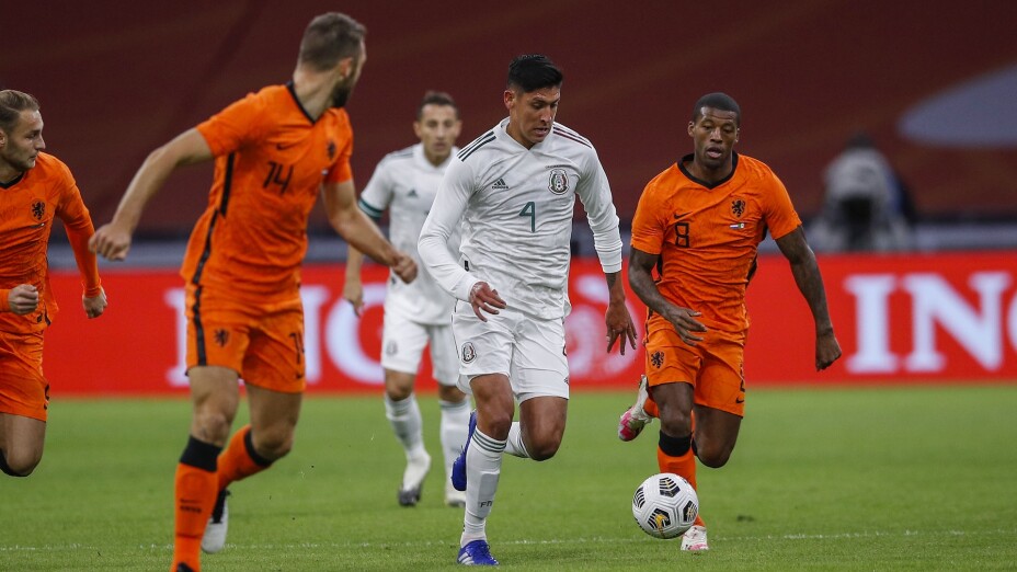Edson Álvarez de México entre dos jugadores de Holanda