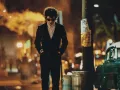 Los trajes de los personajes reflejan la influencia del movimiento artístico y cultural que marcó a la ciudad, con prendas que evocan tanto el estilo casual como la elegancia despreocupada de los artistas y músicos de esa era. La diseñadora Arianne Phillips ha logrado un equilibrio perfecto entre la autenticidad histórica y la expresión individual de los personajes.
Crédito: Searchlight Pictures