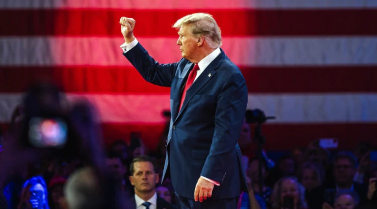 Donald Trump con una bandera de Estados Unidos de fondo