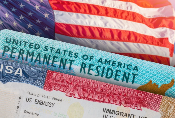 Una bandera de Estados Unidos, una Green Card y una visa americana.