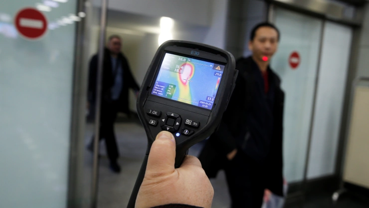 Kazakh sanitary-epidemiological service worker uses a thermal scanner to detect travellers from China who may have symptoms possibly connected with the previously unknown coronavirus, at Almaty International Airport