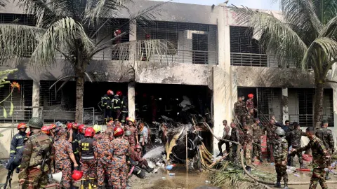Bomberos y soldados trabajan junto a los restos de un avión de entrenamiento de la fuerza aérea después de que se estrellara en el campus de Milestone College, en Daca, Bangladesh , el 21 de julio de 2025