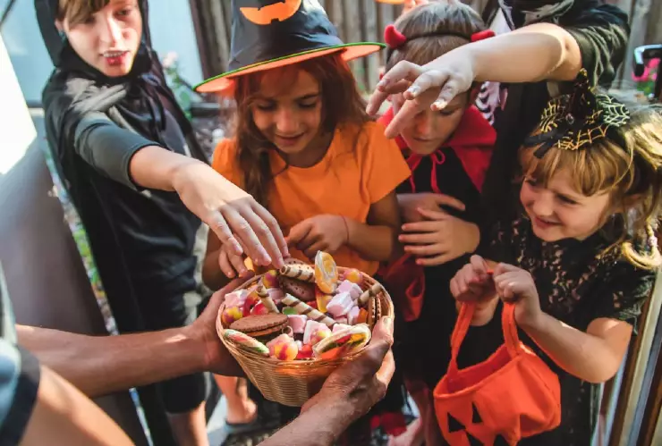 niños felices reciben caramelos en Halloween