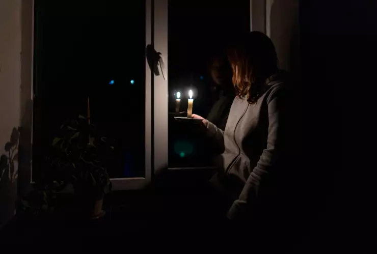 Una mujer sostiene una vela prendida por un apagón