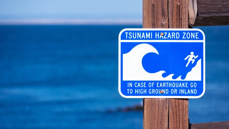 Señal en la playa con las advertencias sobre un tsunami