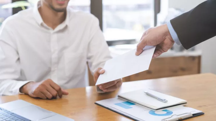Una persona recibe un sobre con un cheque.