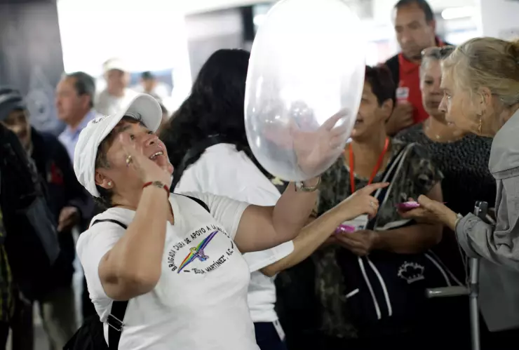 A member of an organization holds an inflated condom during an event organized by AIDS Healthcare Foundation for the International Condom Day, at a metro station in Mexico City