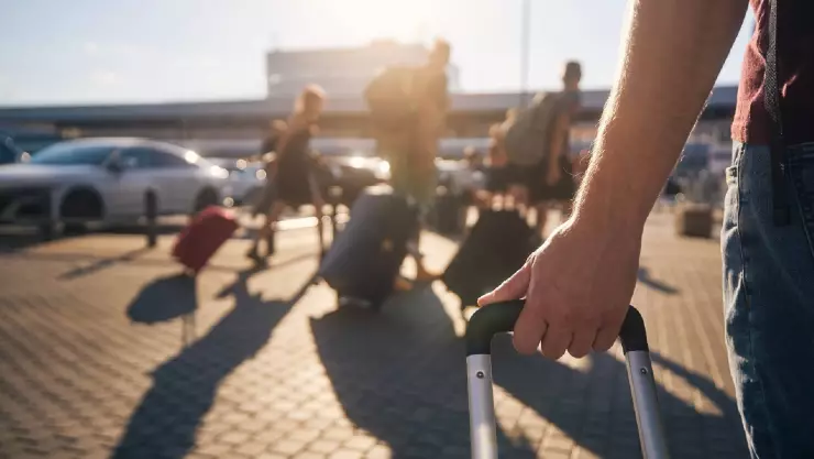 un hombre lleva su maleta al aeropuerto