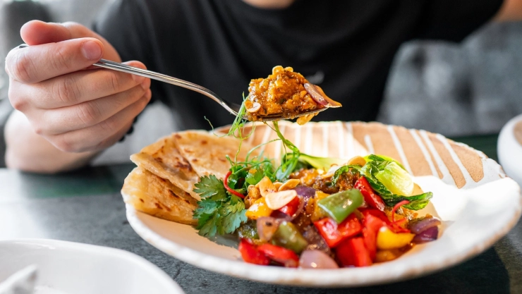 Una persona comiendo de un plato.
