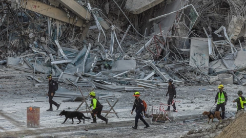 Las fuerzas de rescate caminan junto a los escombros en busca de víctimas del terremoto de Myanmar