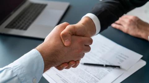 Jefe le da la mano a su empleado