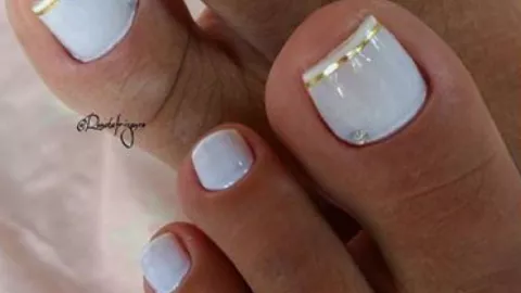 9 diseños de uñas blancas con dorado que puedes usar en los pies para lucir en natación