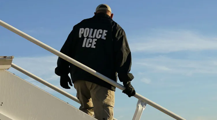 Un agente observa mientras inmigrantes que ingresaron ilegalmente a Estados Unidos son deportados en un vuelo a El Salvador. Imagen, AP.