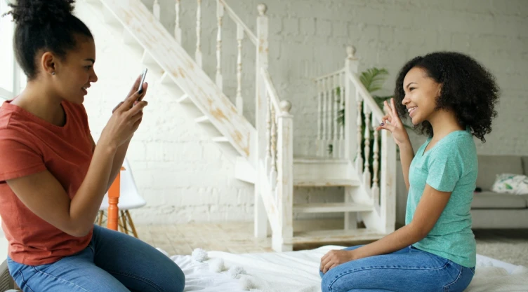 Dos niñas posan para una foto con celular.