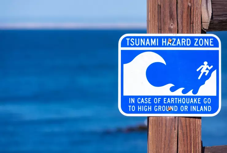 Señal en la playa con las advertencias sobre un tsunami