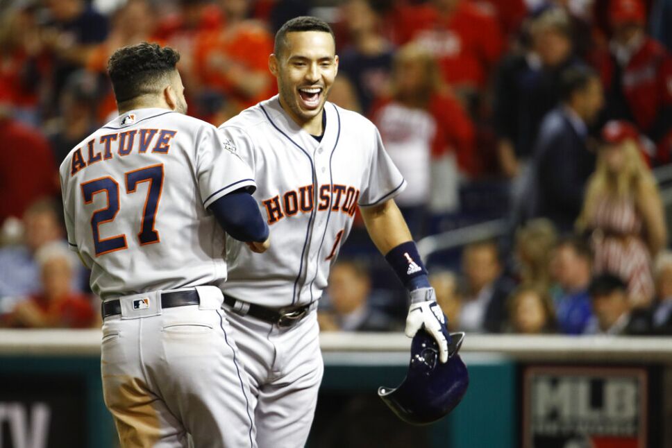 El puertorriqueño Carlos Correa, de los Astros de Houston, festeja con el venezolano José Altuve, tras conectar un jonrón de dos carreras en el quinto juego de la Serie Mundial ante los Nacionales de Washington, el domingo 27 de octubre de 2019. I
