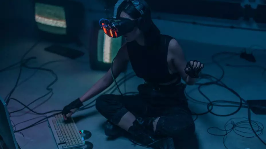 Mujer con lentes de ciberseguridad frente a computadoras.