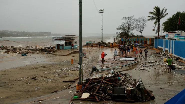 Personas evalúan daños en la costa tras el paso del huracán Erick por la costa del Pacífico, en Puerto Escondido.