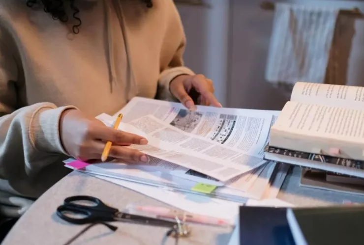 Joven con libro en mano lista para estudiar.