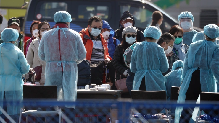 Foto de archivo. Trabajadores ayudan a los pasajeros cuando salen del crucero Diamond Princess, en la Terminal de Cruceros Daikoku Pier, en Yokohama, Japón.