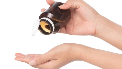 Una mujer sostiene un frasco de pastillas sin píldoras