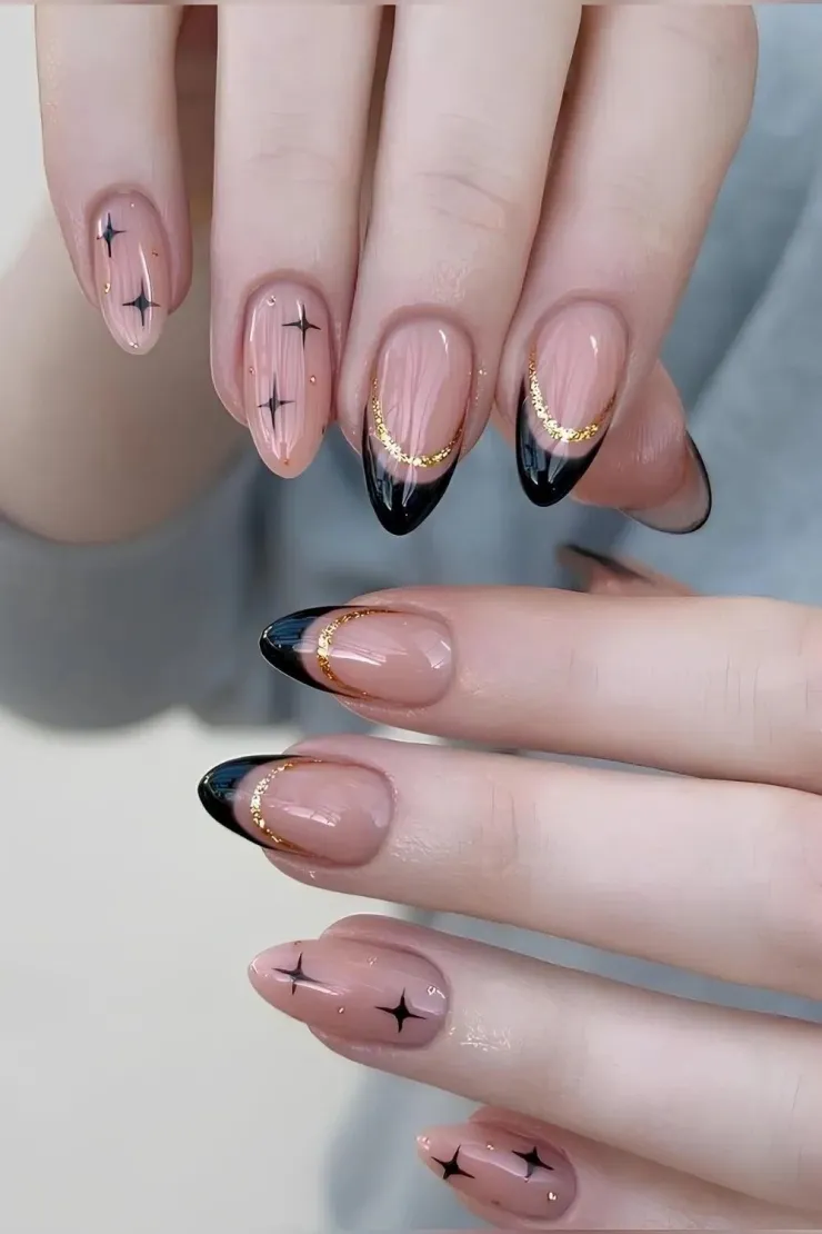 Los toques dorados dan un efecto de uñas galácticas minimalistas