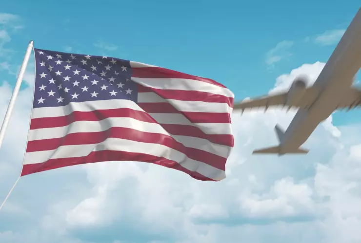 Un avión en el cielo sobre una bandera estadounidense.