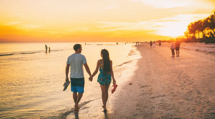 Una pareja camina por una playa de Florida.