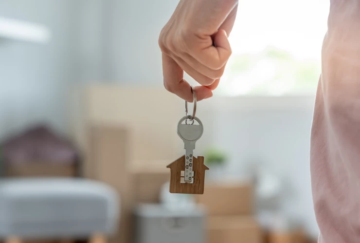 una mujer abre la puerta de su nueva casa.