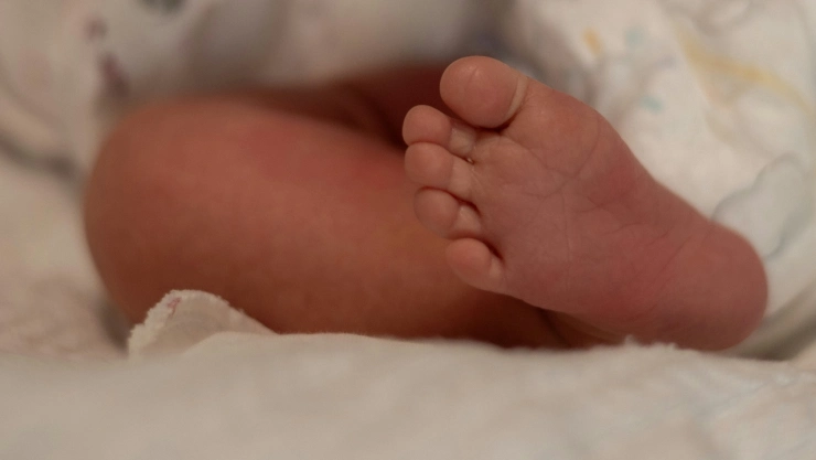 Pie de bebé recién nacido en cuna de hospital.