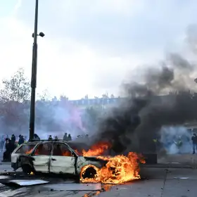 Un auto arde en París durante una protesta contra el alto costo de vida.