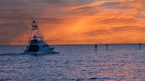 Un pequeño barco pesquero navegando las aguas del Golfo de México al atardecer