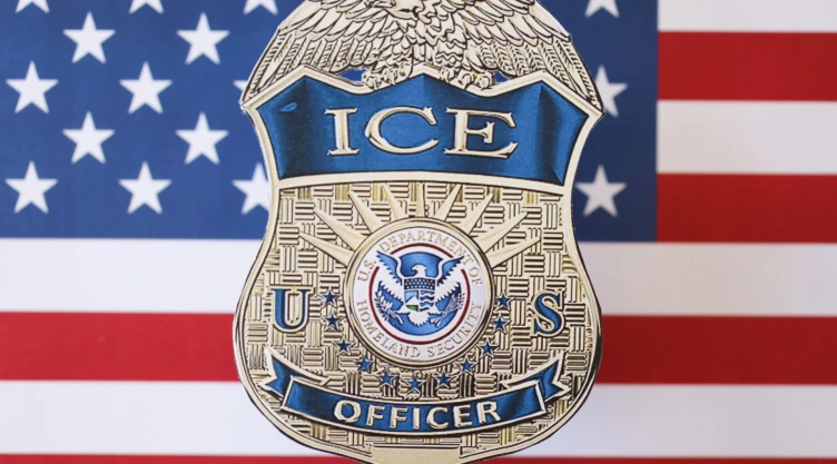 Placa de oficial del ICE sobre bandera estadounidense