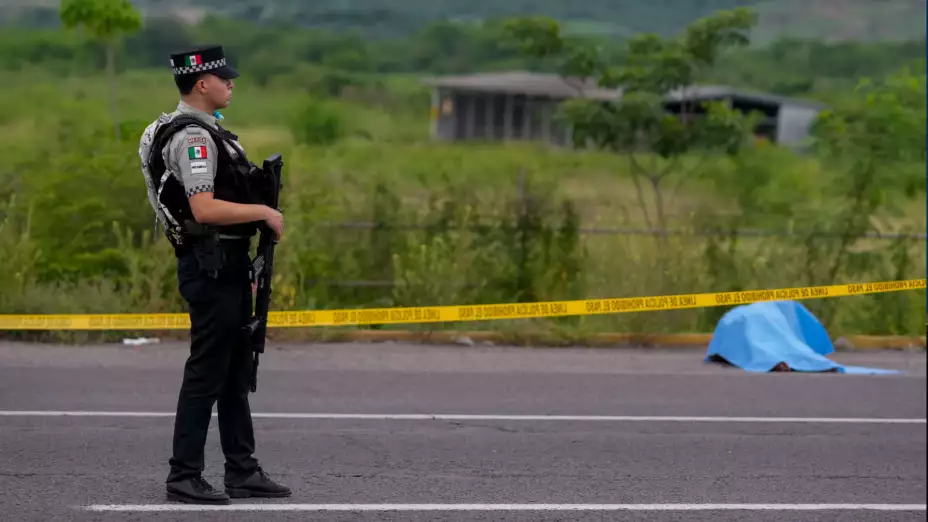 Miembro de la Guardia Nacional frente a un cadáver en Culiacán.